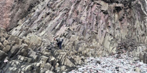 A rockhound collecting minerals in a basalt deposit on Cape d'Or in Nova Scotia